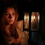 Woman holding a lantern during a spooky night tour in Sydney
