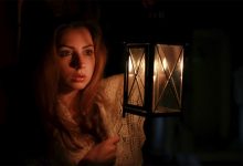 Woman holding a lantern during a spooky night tour in Sydney