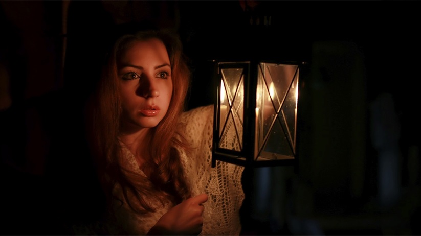 Woman holding a lantern during a spooky night tour in Sydney